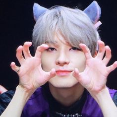 a person with grey hair and cat ears covering their eyes