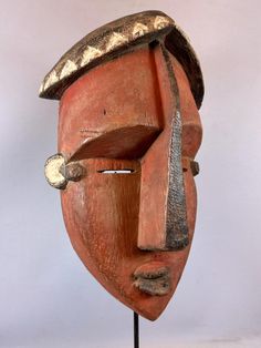 a wooden mask with a hat on it's head