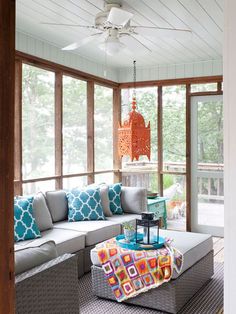 a living room filled with lots of furniture and pillows on top of a wooden floor