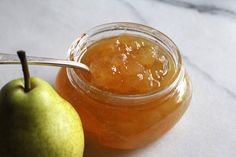 an apple and honey sit next to each other on a counter top with a spoon in it