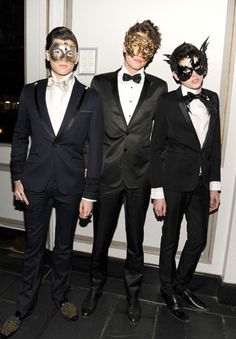 three men in tuxedos and masks standing next to each other