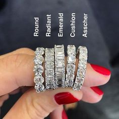 a woman's hand is holding three rings with diamonds on each one and the other side