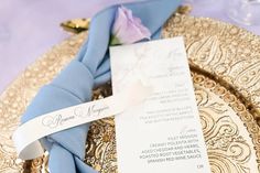 a place setting on a gold plate with a blue napkin