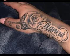 a person with a rose tattoo on their left hand and the word'love'in cursive writing