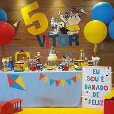 the table is set up with balloons and decorations