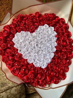 a heart shaped box filled with red and white roses