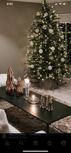 a living room with a christmas tree in the corner and decorations on the coffee table