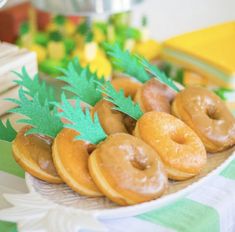 there are many doughnuts on the plate with pineapple decorations around them,