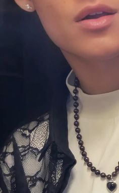 a close up of a person wearing a necklace with pearls on it's neck