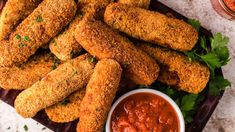 fried chicken sticks on a plate with sauce and parsley sprinkled on the side