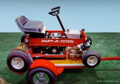 a red lawn mower sitting on top of a green field