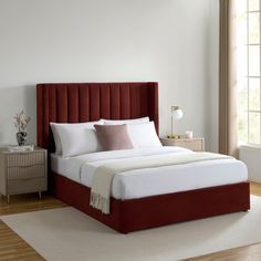 a bed with white sheets and red headboard