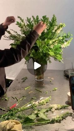 a man is making flowers in a vase