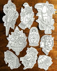 some stickers that are on top of a wooden table with flowers and birds in them