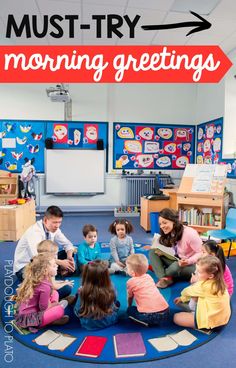 a group of children sitting on top of a blue rug in front of a classroom