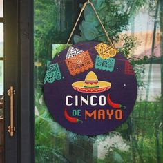 a sign that says cinco de mayo hanging from the side of a building door