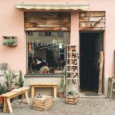 an outside view of a shop with wooden benches