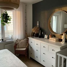 a white dresser sitting next to a window with a mirror on it's side