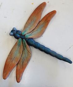 a blue and orange dragonfly sitting on top of a table