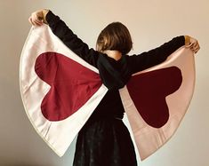 a woman is holding a large heart shaped flag in her hands and wearing a black dress