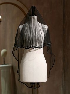 a white mannequin with a black veil on it