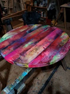 a table made out of old pallets and painted with different colors on it in a workshop