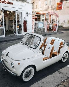 an old white car is parked on the street