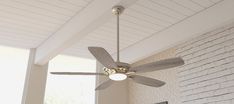 a ceiling fan is hanging from the ceiling in a room with white brick walls and flooring