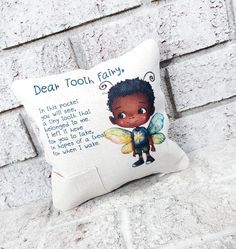 a pillow with the words dear tooth fairy printed on it, sitting against a brick wall