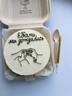 a cake in a box with writing on it and a fork next to the plate