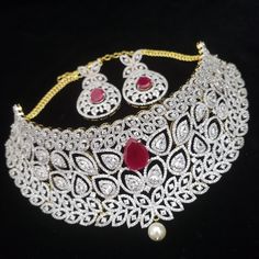 "Handmade Indian Jewelry, best to wear for traditional ceremonies or Indian wedding. This bridal jewelry has ethnic finish. It has very high quality ADs with ruby It is a Bollywood style one gram jewelry. Handmade Indian Jewelry item * Necklace Set is a combo of Necklace & Stud Earrings * Necklace is adjustable with adjustable back chain/ Dori/ Cord * Earring Length: 2\", Earring Width: 1.0\" * Choker : Main design 8 inches. Center 2.5 inches * Gold Color is gold tone which has a bright gold American Diamond Chandbali Bridal Necklace For Festivals, Traditional Cubic Zirconia Necklaces For Receptions, Traditional Cubic Zirconia Bridal Necklace For Reception, Traditional Heavy Diamond Bridal Necklace, Traditional Bridal Necklace With American Diamonds, Formal Ruby Jewelry For Diwali, Traditional American Diamond Bridal Necklace For Formal Events, Elegant Ruby Bridal Necklace For Ceremonial, Traditional Jewelry With 17 Jewels For Reception