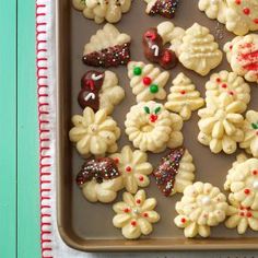 cookies decorated with icing and sprinkles are on a baking sheet, ready to be eaten