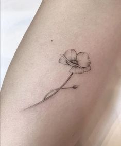 a single flower tattoo on the thigh