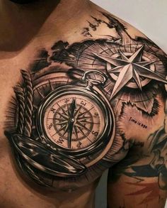 a man's chest with a compass tattoo on it