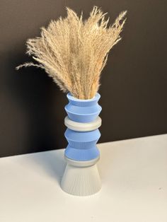 a blue vase with some dry grass in it