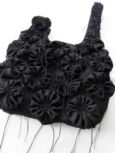 a black purse with large ruffles on it