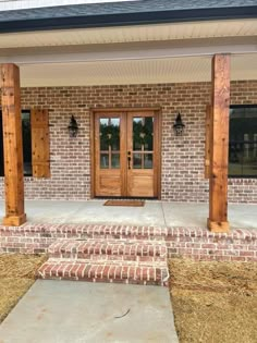 a brick house with wooden doors and pillars