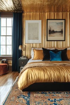 a large bed with gold sheets and pillows in a room that has blue drapes on the windows