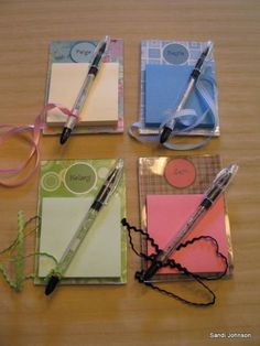 four notepads and two pens on a table