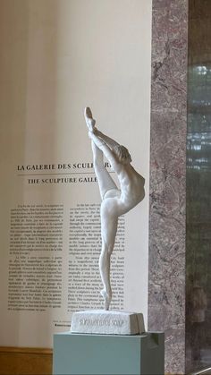 there is a statue in front of a wall with words on it that read la garbie des scul