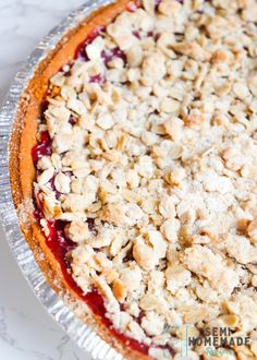 a pie with crumbled toppings sitting on top of a white countertop