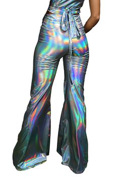 Step into the future with our mesmerizing holographic silver bell bottoms, a dazzling fusion of retro charm and futuristic allure. These eye-catching disco flares are crafted to captivate, boasting an otherworldly shine that transforms every movement into a hypnotic show. Designed with both style and comfort in mind, these pants feature a figure-hugging fit that seamlessly transitions into a dramatic flare, flattering all body shapes and sizes. More than just a piece of clothing, these pants are Trendy Shiny Party Bottoms, Metallic Shiny Bottoms For Party Season, Trendy Shiny Bottoms For Party, Metallic Disco Bottoms For Spring, Metallic Flare Pants For Party, Metallic Disco Bottoms For Party, Disco Flare Party Bottoms, Disco Flare Bottoms For Party, Fitted Shiny Disco Pants