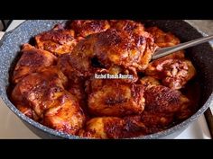 a pan filled with meat sitting on top of a stove