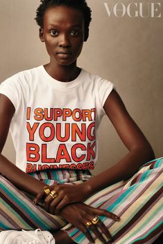 a woman sitting on top of a bed wearing a t - shirt that says i support young black bloggers