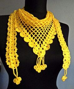 a yellow crocheted scarf on a mannequin