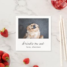 a card that says drinks run me with strawberries next to it on a marble surface