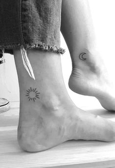 two people with matching tattoos on their feet, one has a feather and the other has a sun