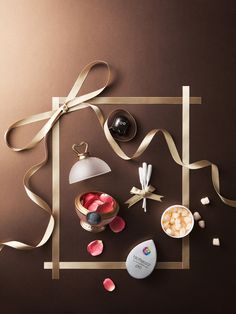 an assortment of candies and confections on a brown background with gold ribbon