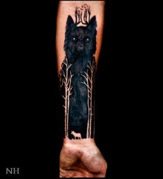 a man's arm with a wolf and trees on it