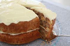 a cake with white frosting is on a glass plate